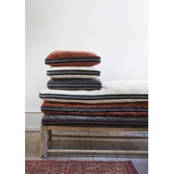 Siddepude i burnt red og sort velour og bomuld placeret p� stol med moderne og hyggelig boligindretning