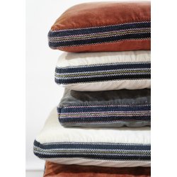 Bl�d siddepude i gr� og sort bomuld og velour placeret p� stol i moderne boligindretning